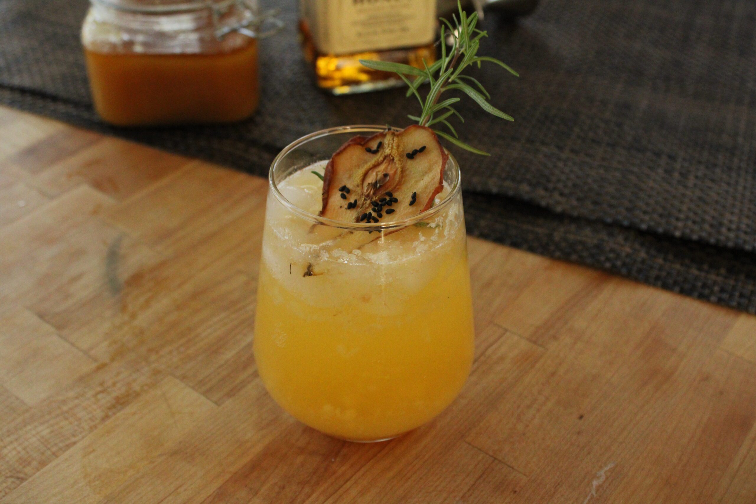 Honey whiskey and orange bitters muddled into ripe pear create a stunning fall cocktail.