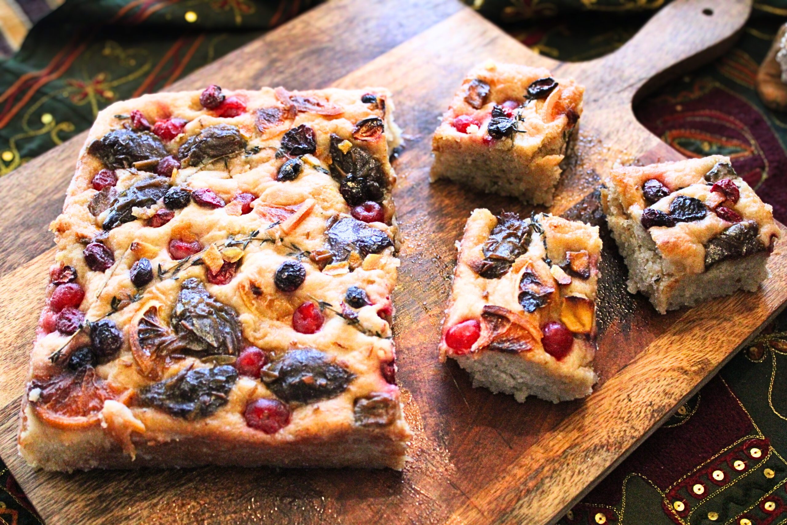 Focaccia fruitcake topped with dried fruit and citrus, baked golden and airy for a modern holiday dessert